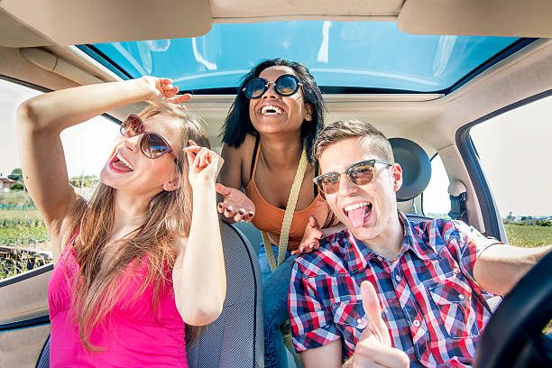cheerful friends with big smiles having fun in car stock photo