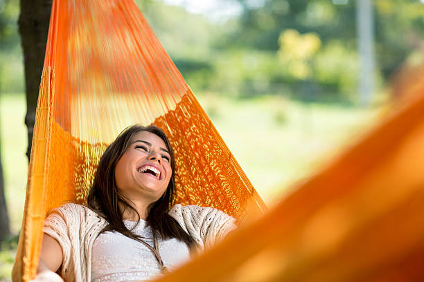Cheerful girl enjoy in hammock Cheerful girl enjoy in orange hammock outdoor resting stock pictures, royalty-free photos & images