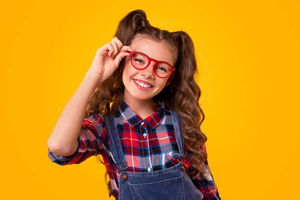 Cheerful girl in stylish glasses looking at camera stock photo