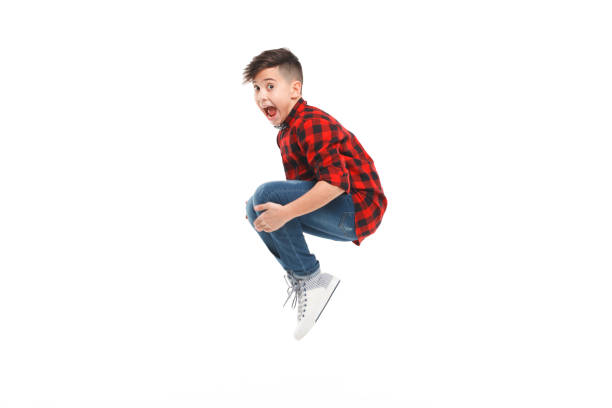Cheerful jumping boy Side view of excited young boy jumping isolated on white. boy jumping stock pictures, royalty-free photos & images