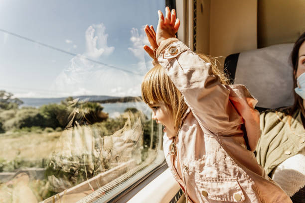 Cheerful little girl looking at the scenery from the train stock photo