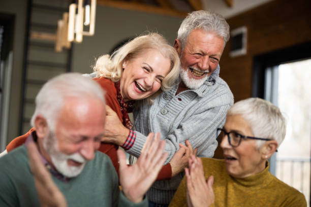 Cheerful mature couples laughing at home. stock photo