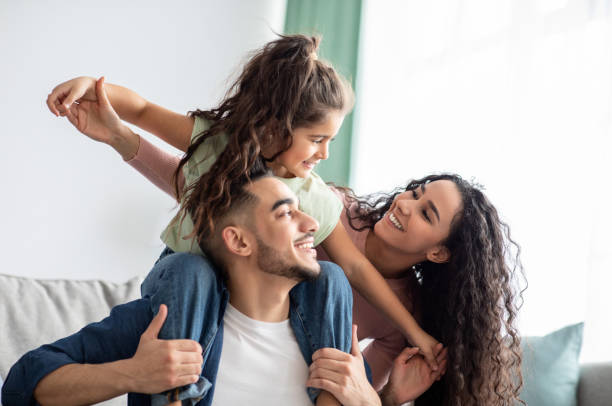 cheerful middle eastern family of three having fun together at home - família imagens e fotografias de stock