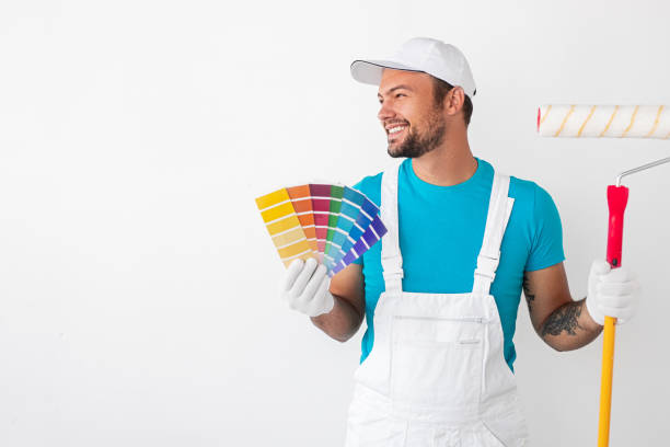 Cheerful painter with roller and samples stock photo