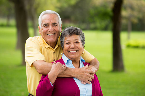 Cheerful Senior couple hugging in the park stock photo