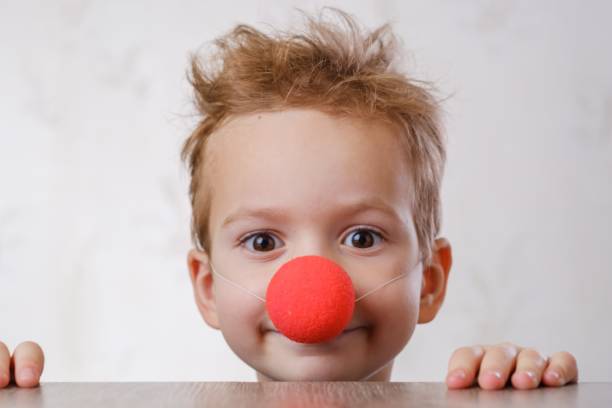 Cheerful shaggy clown Nose clown background white child boy closeup. Kid circus. clown's nose stock pictures, royalty-free photos & images