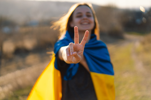 Cheerful ukrainian girl that shows a sign of peace or victory. Independence Day. Flag Day. Constitution day.