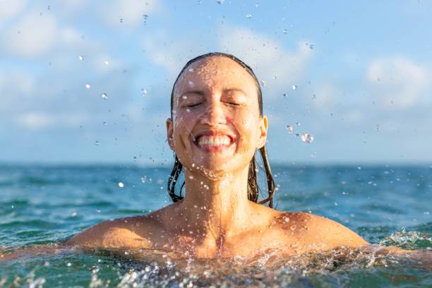Cheerful woman enjoying the summer beach. Happy people in nature. People happy and having fun in summer swimming activity in the ocean water. free jpeg images stock pictures, royalty-free photos & images