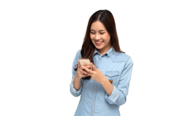 Cheerful young Asian woman using smartphone and receiving good news from the message on mobile chat application over white background Cheerful young Asian woman using smartphone and receiving good news from the message on mobile chat application over white background asian woman using phone stock pictures, royalty-free photos & images