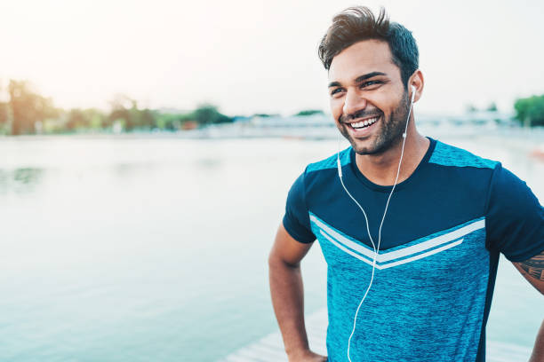 Cheerful young athlete outdoors by the river Portrait of a smiling young Middle-Eastern ethnicity athlete young men stock pictures, royalty-free photos & images