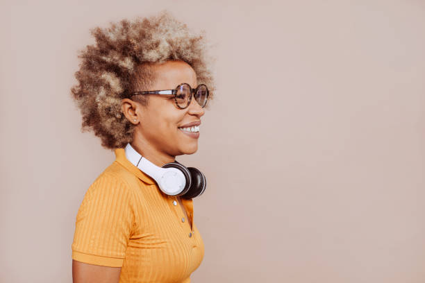 Cheerful young latin american afro woman listening to music stock photo