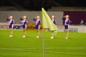 Soccer playing field,corner flag, night shoot ,girls in background before the beginning of the game.