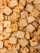 istock cheese biscuits background, square shape crackers 1360553854
