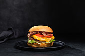 istock Cheese burger with bacon on black dark background 1295796231