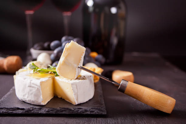 Cheese camembert brie on the board, two glasses and bottle of red wine stock photo