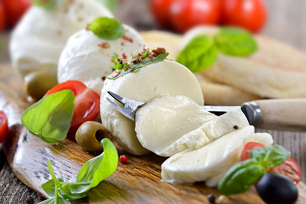 Cheese snack Italian mozzarella cheese snack with cherry tomatoes, basil and olives served on a wooden board with toast bread mozzarella stock pictures, royalty-free photos & images