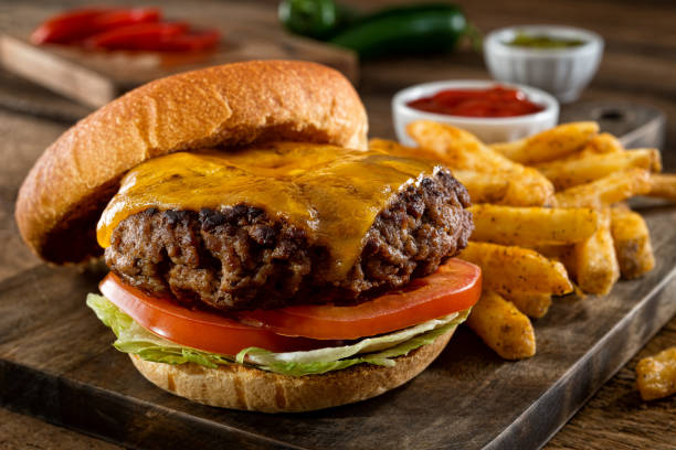 Cheeseburger and Fries A delicious homemade burger with real cheddar cheese and black pepper seasoned french fries. cheeseburger stock pictures, royalty-free photos & images