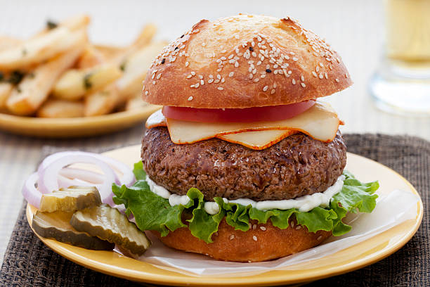 Cheeseburger Big, juicy cheeseburger on an artisan bun. muenster cheese stock pictures, royalty-free photos & images