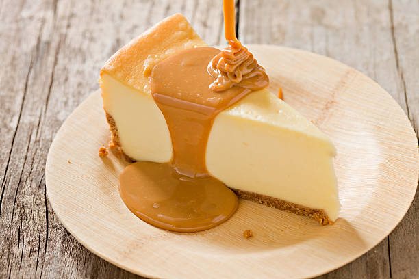 cheesecake with caramel pour - kwarktaart stockfoto's en -beelden