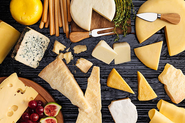 Cheeses selection Top view of a dark table filled with a wide variety of cheeses. french food photos stock pictures, royalty-free photos & images