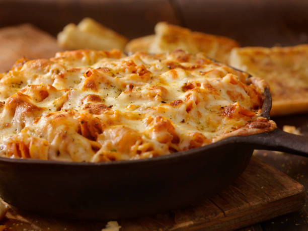Cheesy Baked Rotini Pasta in Roasted Tomato and Garlic Sauce with Garlic Bread Cheesy Baked Rotini Pasta in Roasted Tomato and Garlic Sauce with Garlic Bread gratin stock pictures, royalty-free photos & images