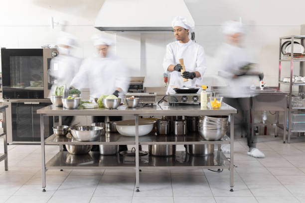 Chef cooks working in professional kitchen stock photo