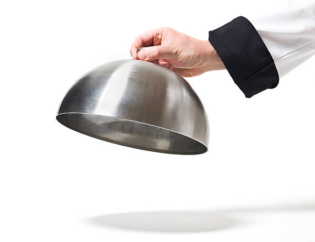 Chef opening cloche lid stock photo