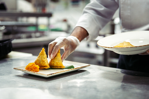 Professional chef platting vegetable samosa
