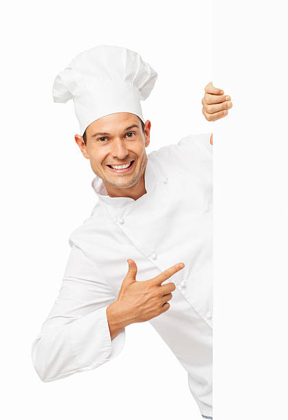 Chef Pointing While Hiding Behind Blank Billboard stock photo