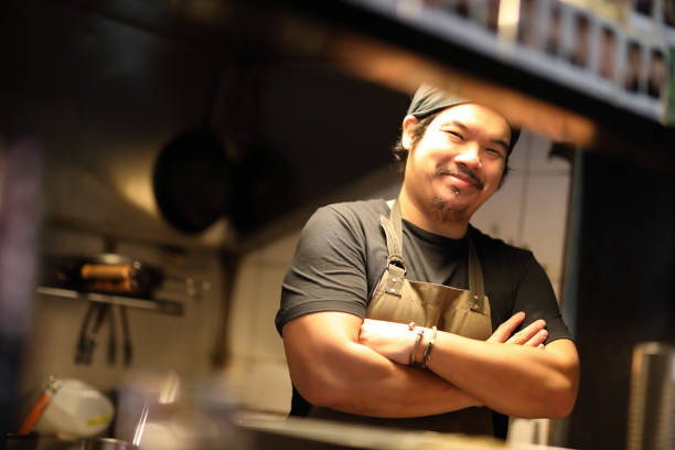 chef bereitet küche im küchenporträt zu - asiatischer koch stock-fotos und bilder