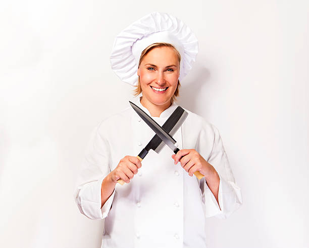 Chef woman on white background with knifes crosed. stock photo