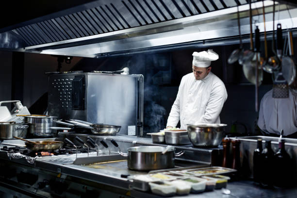 Chef working on the kitchen Chef working on the kitchen commercial kitchen stock pictures, royalty-free photos & images