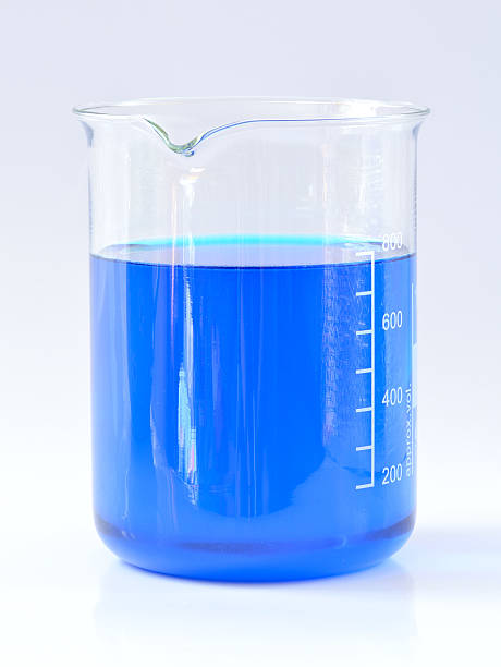 Chemical beaker with blue chemicals dissolved in water stock photo