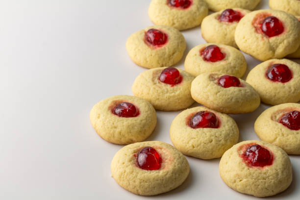 Cherry cookies on white - delicious cherry topped cookie background with space for text stock photo