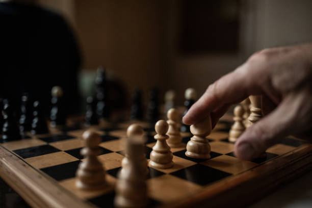 schaakbord en menselijke hand sluiten omhoog - schaken stockfoto's en -beelden