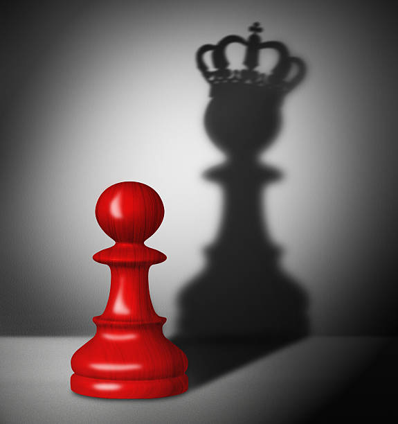 Chess pawn with the shadow of a king stock photo