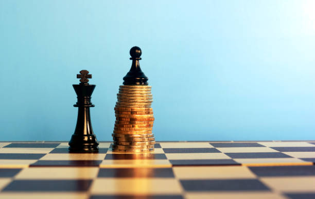 Chess pieces on stacked coins stock photo