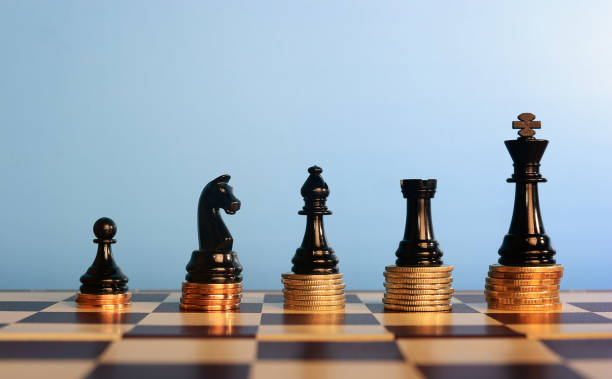 Chess pieces on stacked coins, stock photo