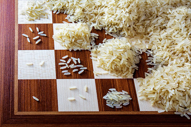 chessboard with expotential growing heaps of rice grains, concept stock photo