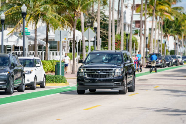 Chevy Suburban lux uber suv or lyft rideshare vehicle cruising Miami Beach Ocean Drive stock photo