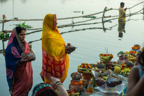 Chhath Pooja Indian women performing Hindu rituals during "Chhath Puja" in polluted river Yamuna. chhath stock pictures, royalty-free photos & images