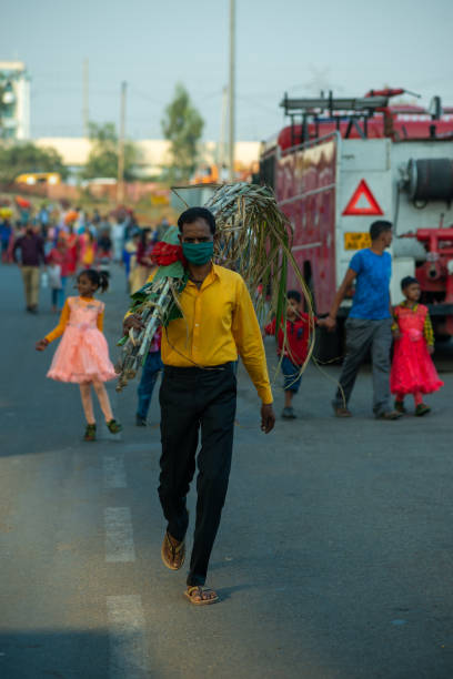 Chhath Pooja Man walking towards river Yamuna with religious offerings on his shoulder to pray sun god during 'Chhath Puja' festival. chhath stock pictures, royalty-free photos & images