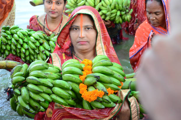 Chhath puja celebrated by Hindu women KOLKATA- OCTOBER 2017: Indian women offering her prayers with fruits and bundle of bananas during the festival of Chhath Puja. Chhath is an ancient Hindu Vedic festival mainly celebrated in Bihar . chhath stock pictures, royalty-free photos & images
