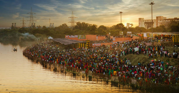 Chhath Puja in Yamuna riverside New Delhi, India, 17 November 2015: Indian devotees worshiping Sun God on the occasion of Chhath festival on the river Yamuna in New Delhi,India. The Chhath festival dedicated to the Sun God and his wife Usha (dawn) chhath stock pictures, royalty-free photos & images