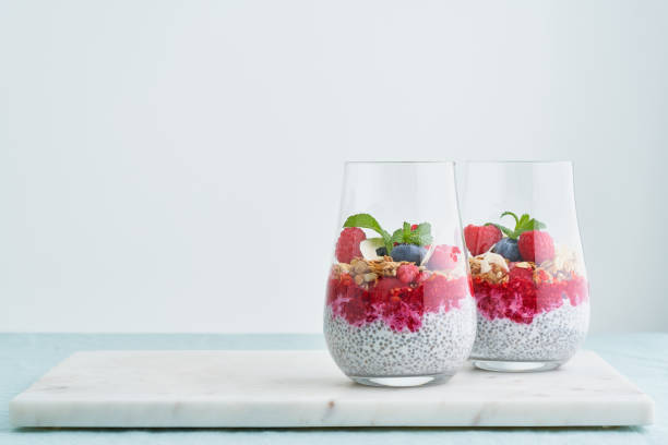 Chia seed, yoghurt, raspberries, blueberries, oat, almonds, mint. Superfood parfait in glass stock photo
