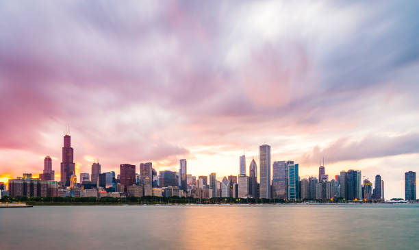 Chicago skyline at sunset with cloudy sky and reflection in water. stock photo