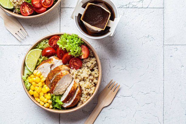 Chicken and quinoa salad with corn and tomatoes in craft eco bowl. Zero waste, to go food, recycling packaging, eco friendly concept. stock photo