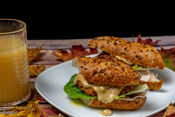 Chicken burger in seeds baguette with olive jalapenos dressing with pear juice stock photo
