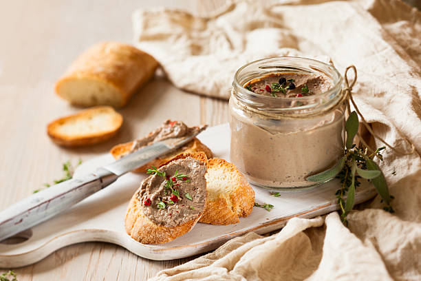 Chicken liver pate on a baguette Chicken liver pate on bread and in jar pate stock pictures, royalty-free photos & images