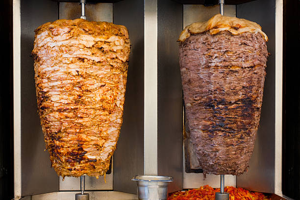 Chicken Mutton Middle Eastern Fast Food Meat "Vertical slabs of skewered fast food shawerma chicken and lamb meat turn on a spit, typical fast food in Middle Eastern restaurants" shawarma stock pictures, royalty-free photos & images